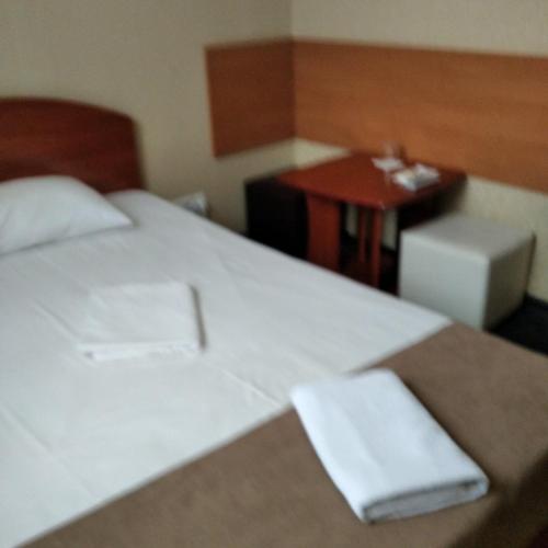 a bedroom with a large white bed and a table at Hotel LaMa 2 in Kyiv