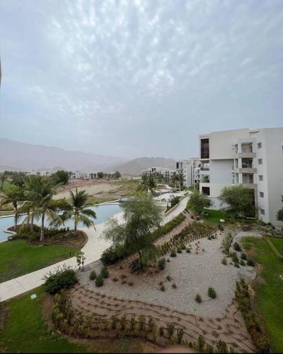 ariaal uitzicht op een park met een gebouw en een meer bij Amazing gateway in Jebel Sifah in Muscat