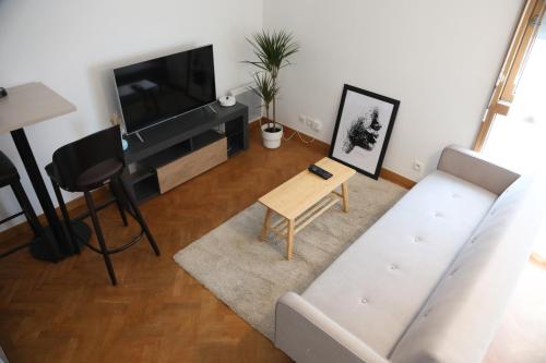 ein Wohnzimmer mit einem Sofa und einem Tisch in der Unterkunft La suite Prestige de Saint Cyr in Saint-Cyr-lʼÉcole