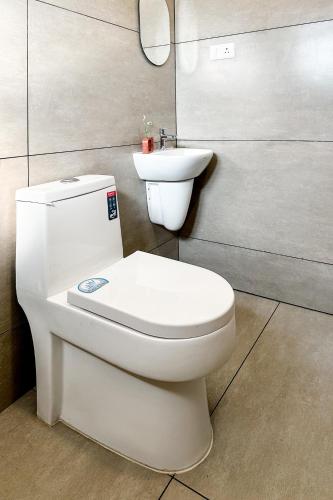 a bathroom with a white toilet and a sink at Avalon Homes in Perintalmanna