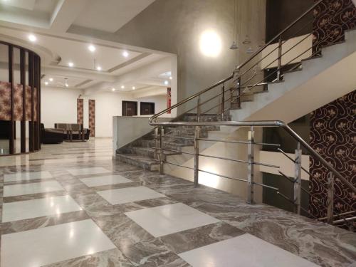 a lobby with a staircase in a building at Hotel Luxura in Siddhapur