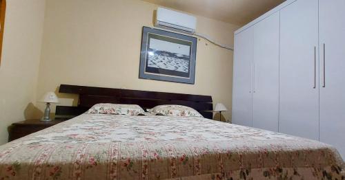 1 dormitorio con 1 cama y TV en la pared en A Famosa CASA BRANCA Da Barra! Suíte 9 Clássica! en Río de Janeiro