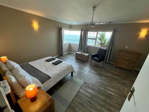 a bedroom with a bed and a desk and a chair at Whitewaters, 2 Bedroom Apartment in Sea View