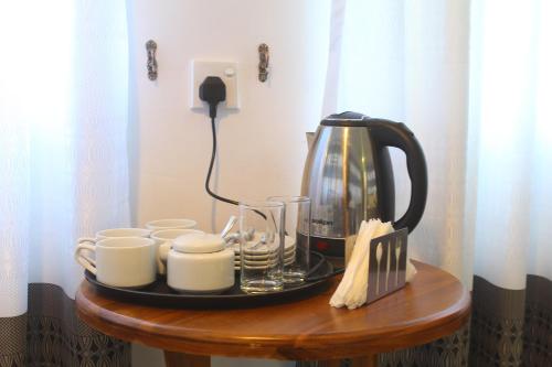 a coffee maker and cups on a table at Triniton Holiday Villas in Hatton