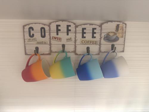 a group of coffee cups hanging from a wall at Joyful Journeys in Dubai