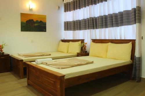 two beds sitting in a room with a window at Triniton Holiday Villas in Hatton