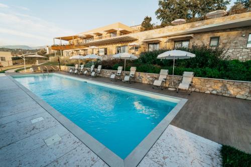a swimming pool with chairs and umbrellas in front of a building at Apartments Monsurei, Lake view in Bardolino