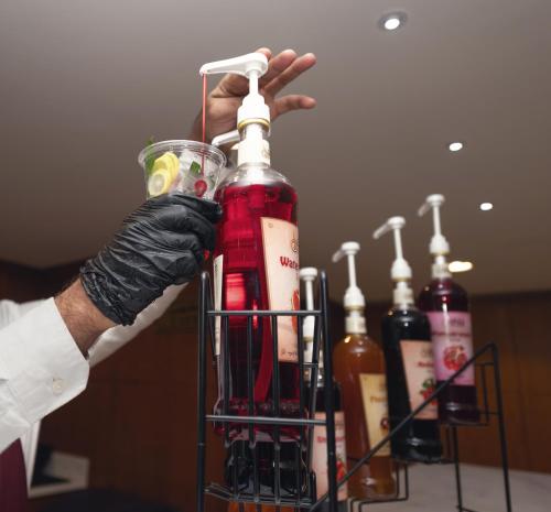 a person is holding a bottle of wine at فندق روز جدة 2 in Jeddah