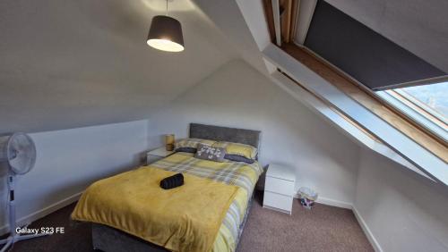 a small bedroom with a bed in a attic at Three Bedroom Apartment with Roof Terrace Near City Centre in Cardiff