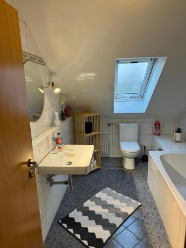 a bathroom with a sink and a toilet and a tub at *ALL NEW* Exklusive DG-Wohnung, Gemütlich & Modern 