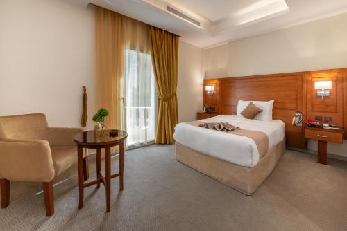 ジッダにあるفندق روز جدة 2のベッドと椅子付きのホテルルーム