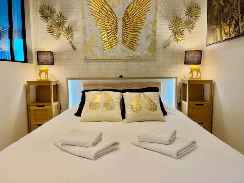 une chambre avec un lit blanc avec deux oreillers dans l'établissement L'Ange Au Sourire, à Reims