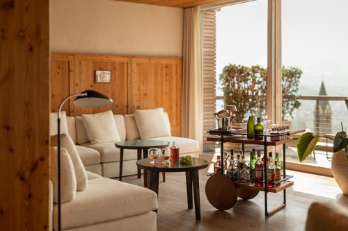 sala de estar con sofá, mesas y ventana en Pergola Residence, en Lagundo