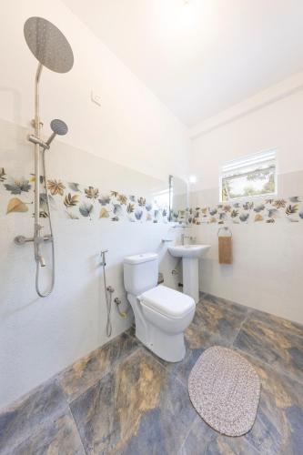 a bathroom with a toilet and a sink at MAKAI Surf House in Ahangama