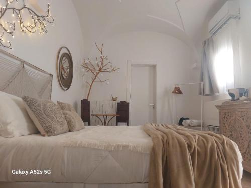 a white bedroom with a bed with a blanket on it at Zahra Superior Suite with private pool in Sannicola