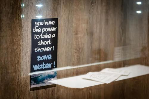 a sign on a wall in a bathroom with a counter at Hotel & Aparthotel Casteau Resort Mons Soignies in Casteau