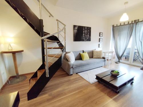een woonkamer met een bank en een trap bij Cozy rooftop with balcony in Praag