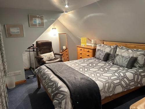 a bedroom with a bed and a chair at 8 Firth Square in Kirkwall
