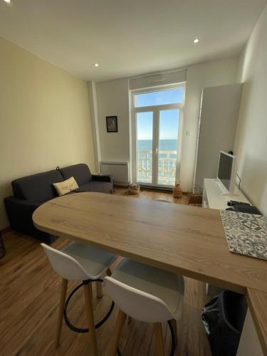 un salon avec une table et un canapé dans l'établissement La mer à perte de vue, Wimereux, côte d opale, à Wimereux