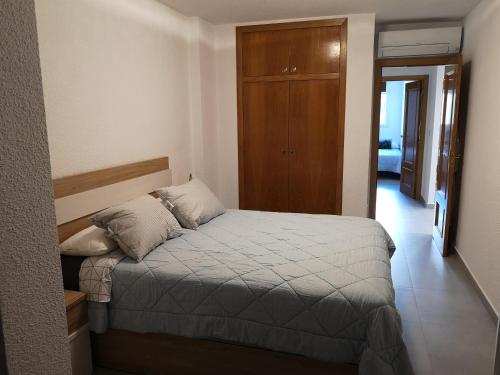 una camera con letto e armadio in legno di Apartamento de diseño con piscina y garaje ad Altea