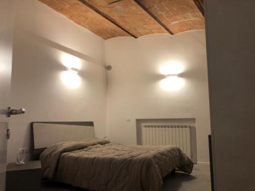 a bedroom with a bed and two lights on the wall at Porta del centro in Gubbio