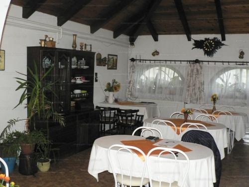 a dining room with white tables and chairs at Szilvi&oacute; in Gyenesdi&aacute;s