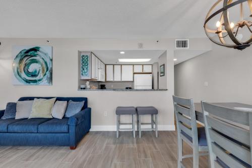 a living room with a blue couch and a table at 2BR Condo with Ocean View in Myrtle Beach