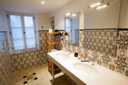 a bathroom with two sinks and a large mirror at Château de Tilly in Boissey-le-Châtel