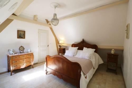 une chambre avec un grand lit et une commode dans l'établissement COSTA DEL PORTE : Maison de charme au coeur du village classé de Beynac avec vue*****, à Beynac-et-Cazenac