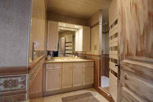 une grande cuisine avec un évier et un miroir dans l'établissement COSTA DEL PORTE : Maison de charme au coeur du village classé de Beynac avec vue*****, à Beynac-et-Cazenac