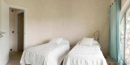 two beds sitting next to each other in a room at trullo contemporaneo in Serranova