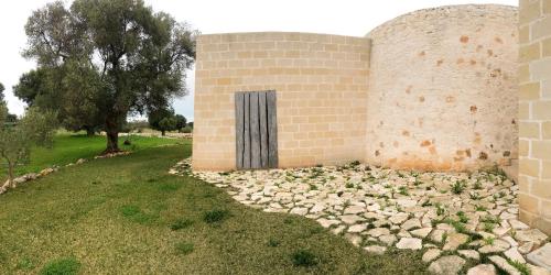 a brick building with a door on the side of it at trullo contemporaneo in Serranova