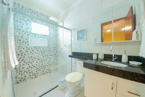 La salle de bains est pourvue de toilettes, d'un lavabo et d'une douche. dans l'établissement Casa de veraneio a 2km da praia, à Porto Seguro