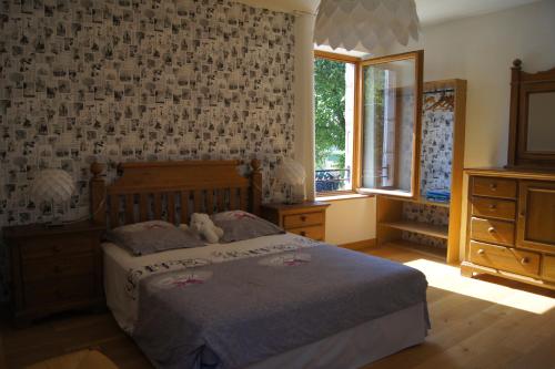a bedroom with a bed with a teddy bear on it at La Maison de Rochebois, chambres et table d'hôtes, Savoie, France in Champagneux