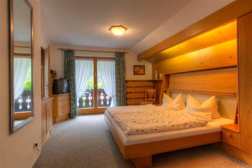 een slaapkamer met een bed en een groot raam bij Gästehaus Manfred in Mittenwald