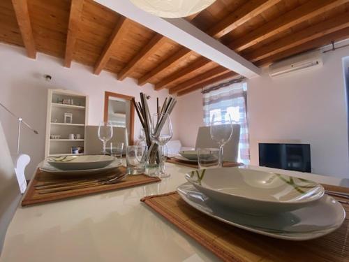 a dining room table with plates and wine glasses at Montesanto 13 in Palermo