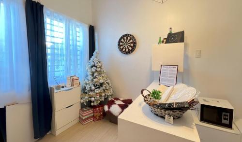 a living room with a christmas tree and a table at Lanara House in Magalang