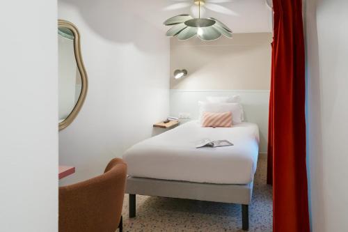 パリにあるTrendy Canettes Hotelのベッドと椅子付きのホテルルーム