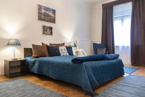 Un dormitorio con una cama azul y una ventana en Central Buda Comfort en Budapest