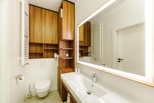 y baño con lavabo, aseo y espejo. en Bel Mare 415B en Międzyzdroje