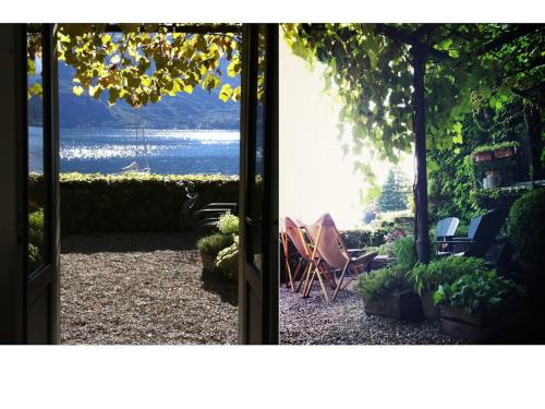 a door leading to a patio with a view of the water at Pescallo Apartments in Bellagio