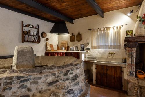 uma cozinha com um balcão de pedra e um lavatório em Ai Torchi Vecchi em Fivizzano