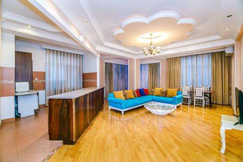 a living room with a blue couch and a table at Deluxe Apartment 142/43 in Baku