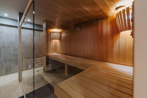 a sauna with wood paneling and a glass door at Nockventure Apartment Nockberge in Ebene Reichenau