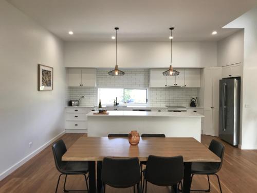 a kitchen and dining room with a table and chairs at A Sanctuary at Denhams - Family & Pooch Friendly in Surf Beach