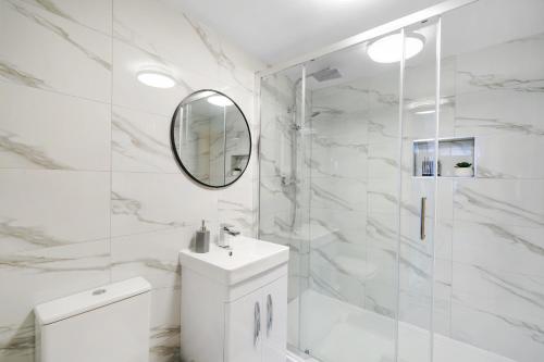 een witte badkamer met een toilet en een spiegel bij Spacious house in Wembley - Garden in Londen