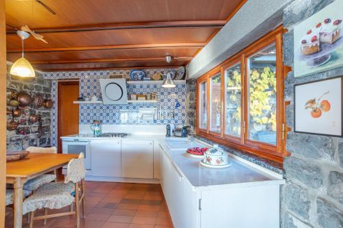 eine Küche mit weißen Schränken und einer Steinmauer in der Unterkunft Charming Villa with Private Pool! in Civenna