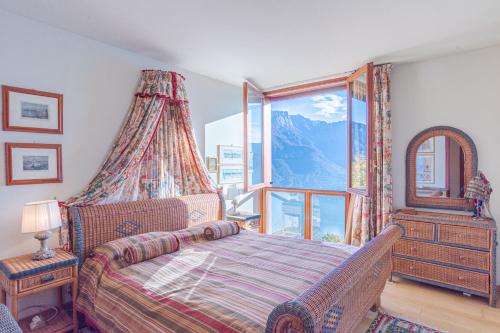 ein Schlafzimmer mit einem Bett und einem großen Fenster in der Unterkunft Charming Villa with Private Pool! in Civenna