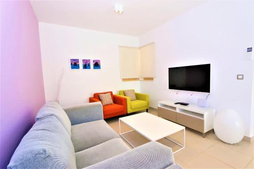 Una sala de estar con un sofá y un televisor. en Cascada Villas, en Novalja