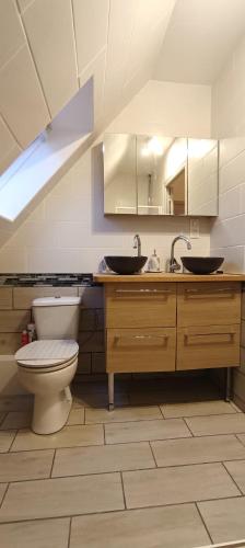 La salle de bains est pourvue de toilettes et de 2 lavabos. dans l'établissement Maison rénovée proche centre-ville et des plages., à Crozon